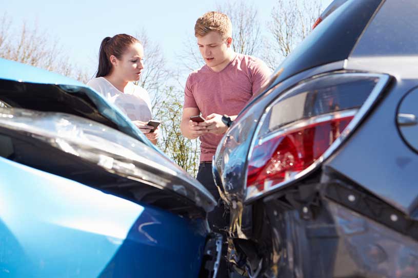 young drivers exchanging insurnace info after car accident