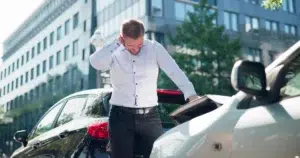 A man holds his neck in pain following a car accident.